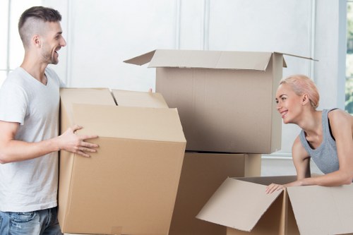 Moving team transporting office furniture through a West London workplace